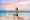 Woman works out on the beach at dawn